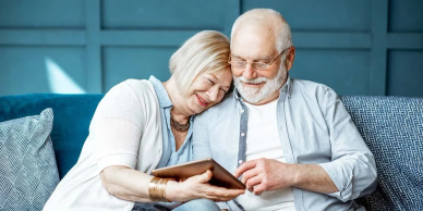 Elderly couple enjoying photos on a tablet.