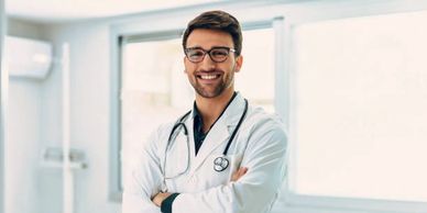 Smiling male doctor with glasses and stethoscope.