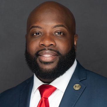 Professional man in suit with red tie and beard.