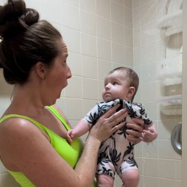 A woman holding a baby with a shocking expression.