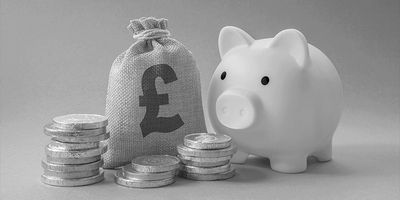 Pink piggy bank with a money bag and stacked coins representing savings.