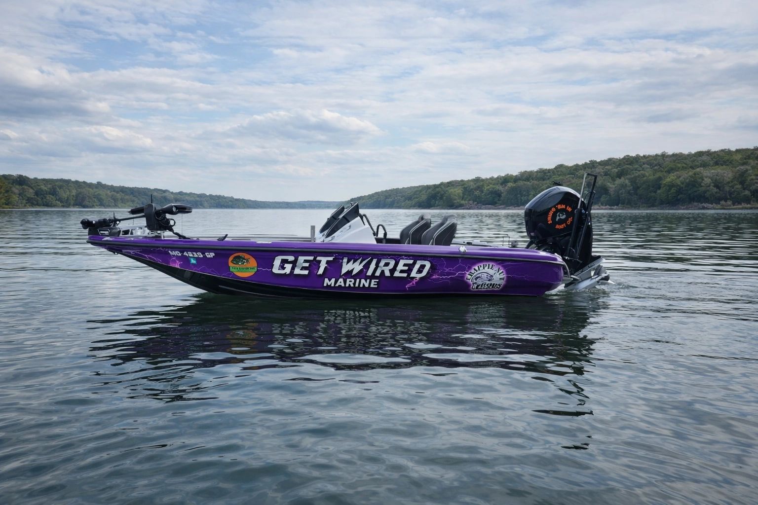 Purple fishing boat named 'Get Wired Marine' on calm water.