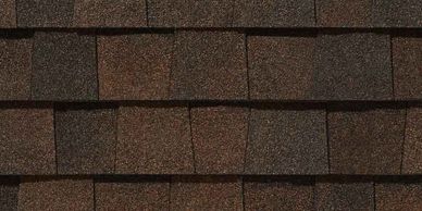 Close-up of brown and dark grey asphalt roof shingles.