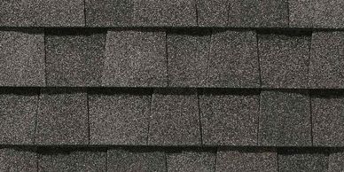 Close-up of gray asphalt roof shingles arranged in overlapping rows.