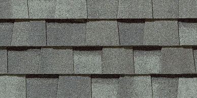 Close-up of gray asphalt roof shingles arranged in rows.