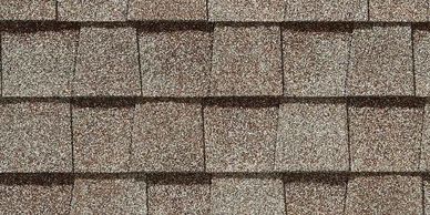 Close-up of brown asphalt roof shingles arranged in overlapping rows.