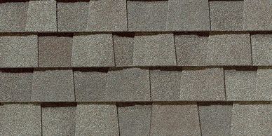 Close-up of textured gray asphalt roof shingles arranged in overlapping rows.