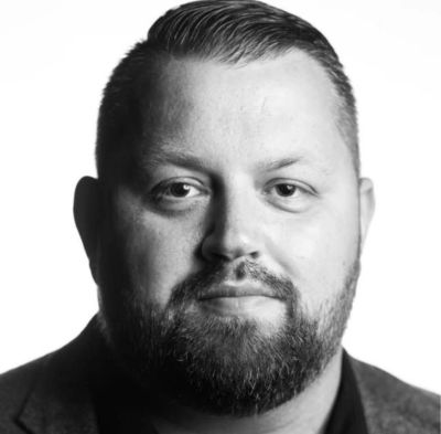 Black and white close-up portrait of a man with a beard.