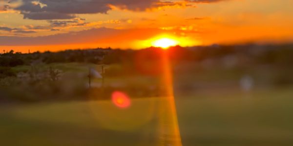 Sunset with orange and yellow hues over a landscape.