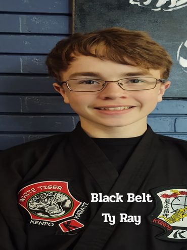Young martial artist Ty Ray in black belt uniform with Kenpo patches.