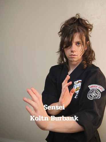 Sensei Koltn Burbank in a martial arts pose wearing a black gi.