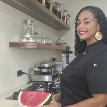 Mujer sonriente con sandía en la cocina.