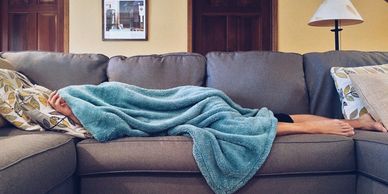A picture of a person taking a nap on the couch