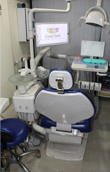 A modern dental clinic setup with equipment and a monitor displaying Crystal Smile logo.