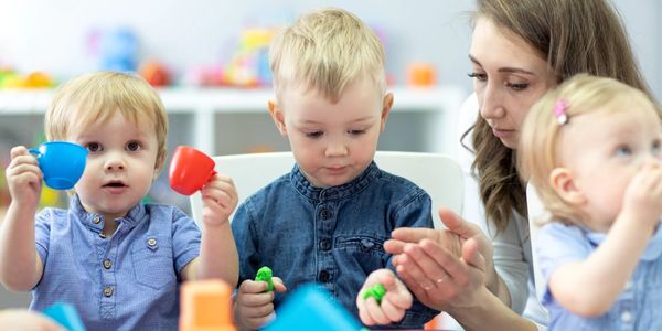 Woman helping children to feed themselves