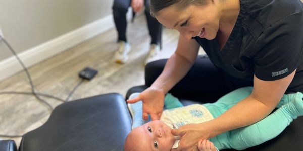 Dr. Haley assessing a baby's condition and preparing a chiropractic plan.