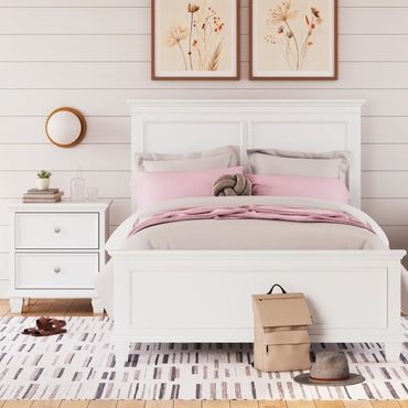 Cozy bedroom with white furniture and soft pink bedding accented by floral art.