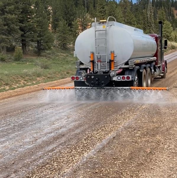 Tanker truck applying product to a dirt road
