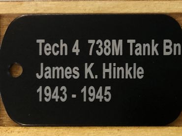 black metal military dog tag reading "tech 4 738M Tank Bn".