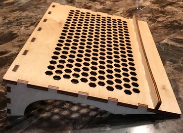 wood laptop stand with engraved name and ventilation holes.