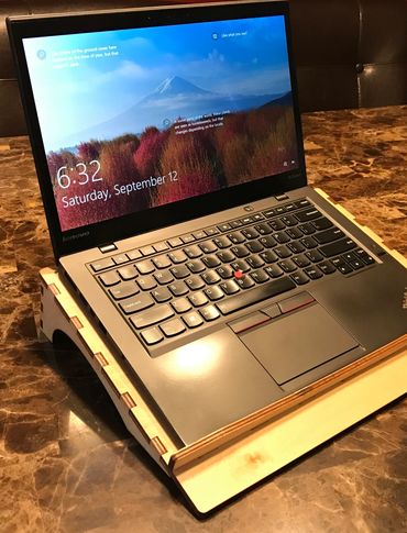 laptop on wood laptop stand with engraved name and ventilation holes.