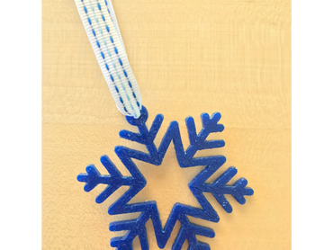 blue snowflake ornament with blue and white ribbon hanger