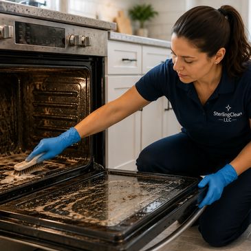 Woman cleaning an oven door with gloves and brush.