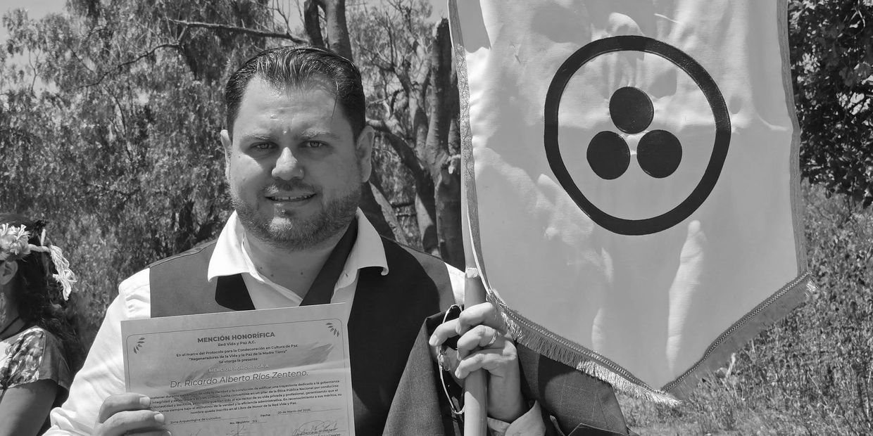 Hombre sostiene certificado y bandera con símbolo circular.