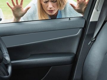 Woman frustrated outside locked car door.