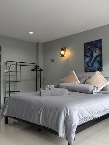 Modern bedroom with a neatly made bed and soft lighting.