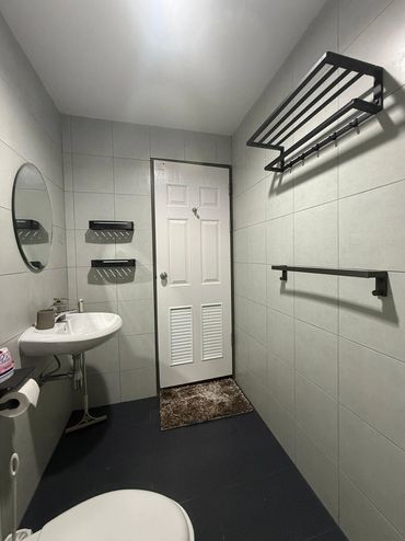 Minimalist bathroom with white door and black fixtures.