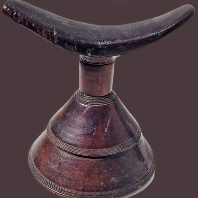 Traditional wooden headrest with a curved top and conical base.