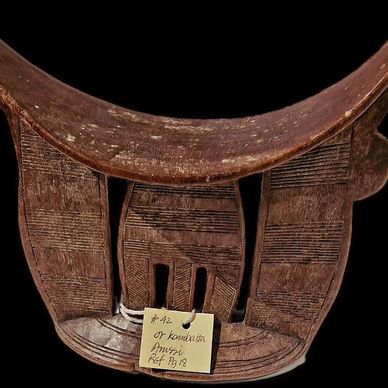 Carved wooden artifact with patterns and a note.
