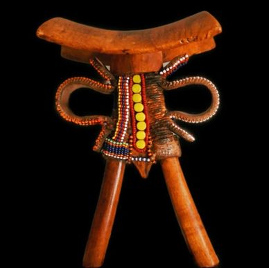 Decorative wooden object with colorful beads on black background.