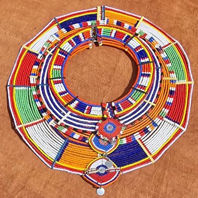 Colorful traditional Maasai bead necklace on a brown background.
