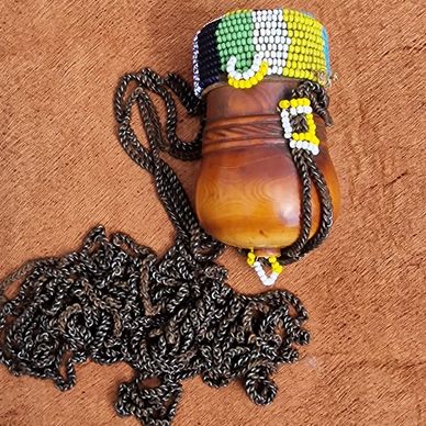 Beaded pouch with a chain on a textured surface.