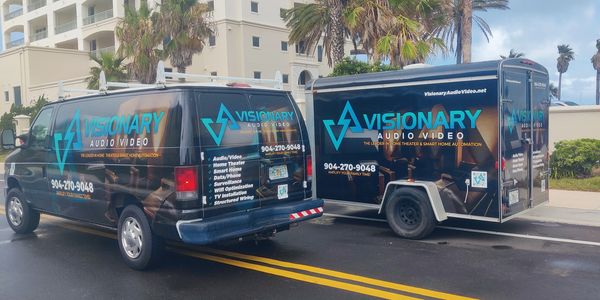 Visionary Audio Video van and trailer parked on a street with palm trees.