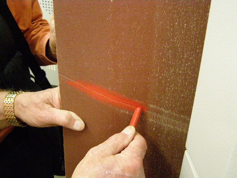 person coloring wood with orange chalk