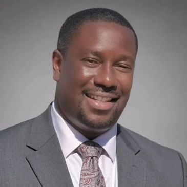 Professional man in a gray suit smiling confidently.