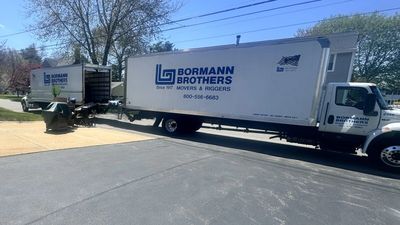 Bormann Brothers moving trucks parked in a driveway.