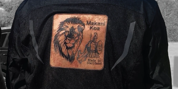 Leather patch on jacket with lion and warrior, labeled Made in Maryland.