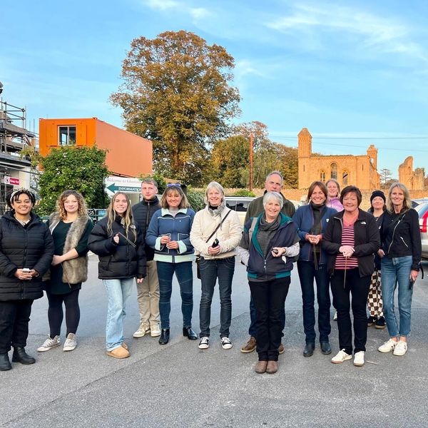 Group on the Glastonbury Ghost Walk. Glastonbury Abbey ruins can be seen in the background