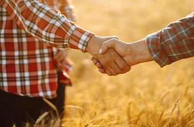 two men shaking hands in a field