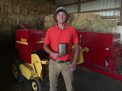 Conner Brown receiving an award in a barn