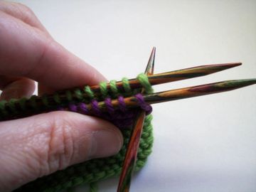 Knitting needles going through stitch on the first and second needle.