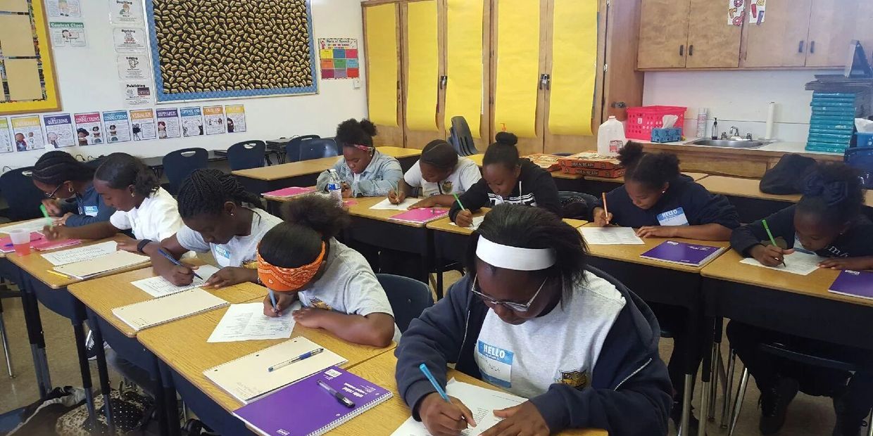 Girls writing at desks.