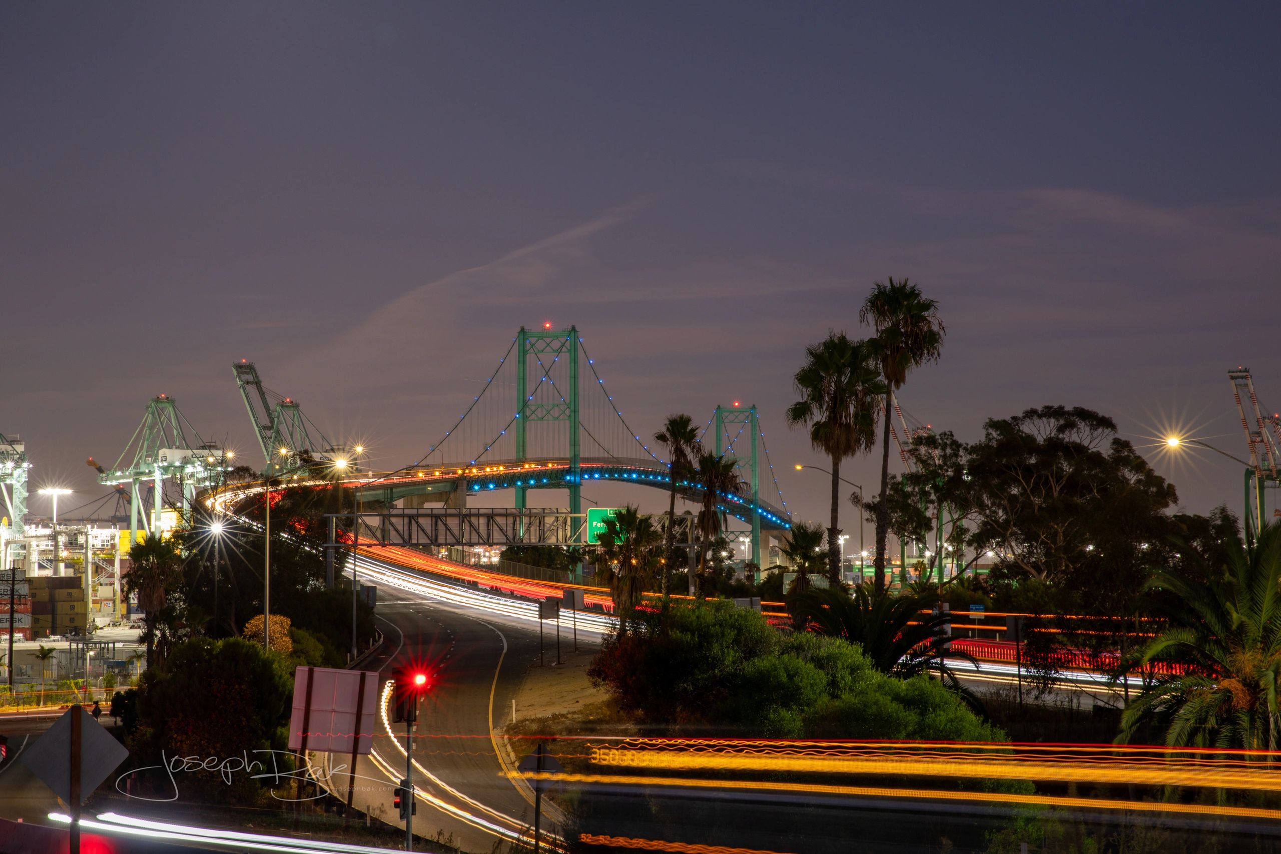 The beautiful Vincent Thomas Bridge in San Pedro and long exposure trucks, cars and busses at night.