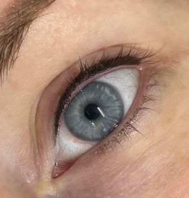 Close-up of a blue eye with detailed iris and eyelashes.