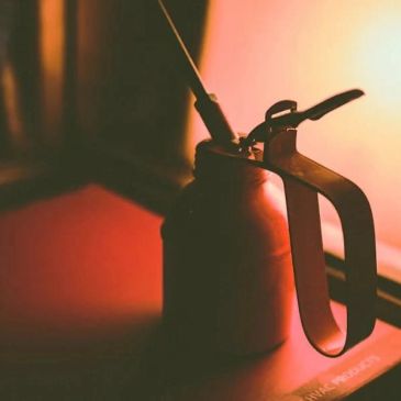 A vintage oil can with a spout and handle.