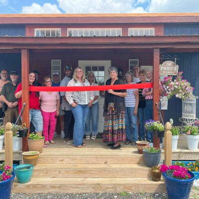 Community ribbon-cutting event at a porch.